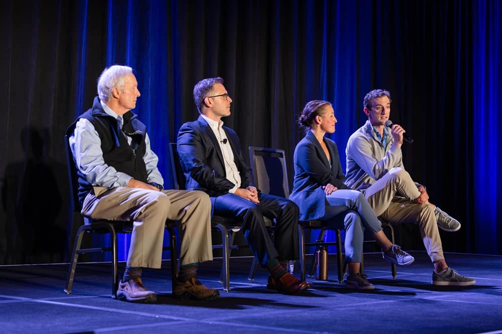 A panel of three man and women on stage.