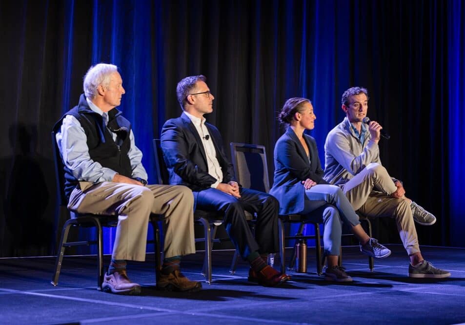 A panel of three man and women on stage.